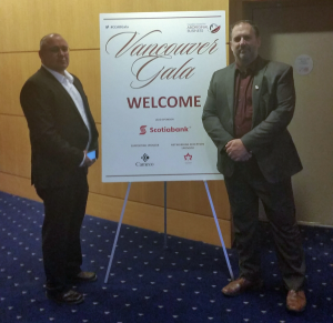 Two men standing with a Vancouver Gala welcome sign