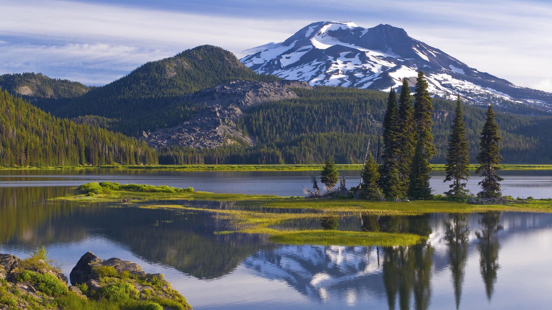 A lake in front of a snow covered mountain